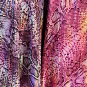 May include: Two pieces of fabric featuring a snakeskin pattern with a metallic sheen. The left piece displays shades of purple and deep violet, while the right piece showcases vibrant magenta and pink tones, both with a textured scale design.
