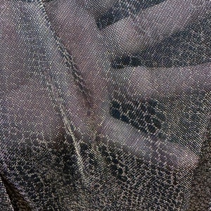 May include: Black fabric with a silver glitter pattern. The fabric has a woven texture.