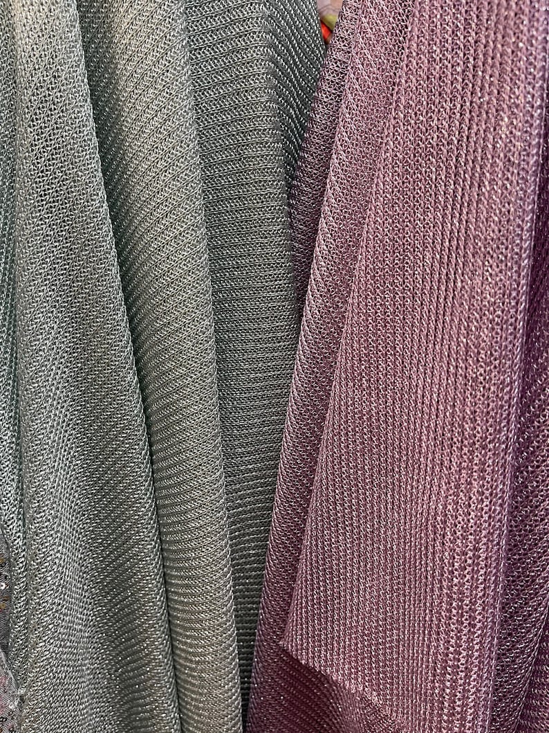 Puede incluir: Primer plano de tres muestras de tela. Las muestras son de color gris claro, gris oscuro y malva. La tela tiene un acabado brillante, met&aacute;lico y un patr&oacute;n texturizado, similar al tejido de punto.
