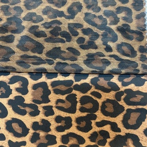 May include: Two fabric swatches with a leopard print pattern. The top swatch is a brown and black mesh fabric. The bottom swatch is a brown and black solid fabric.