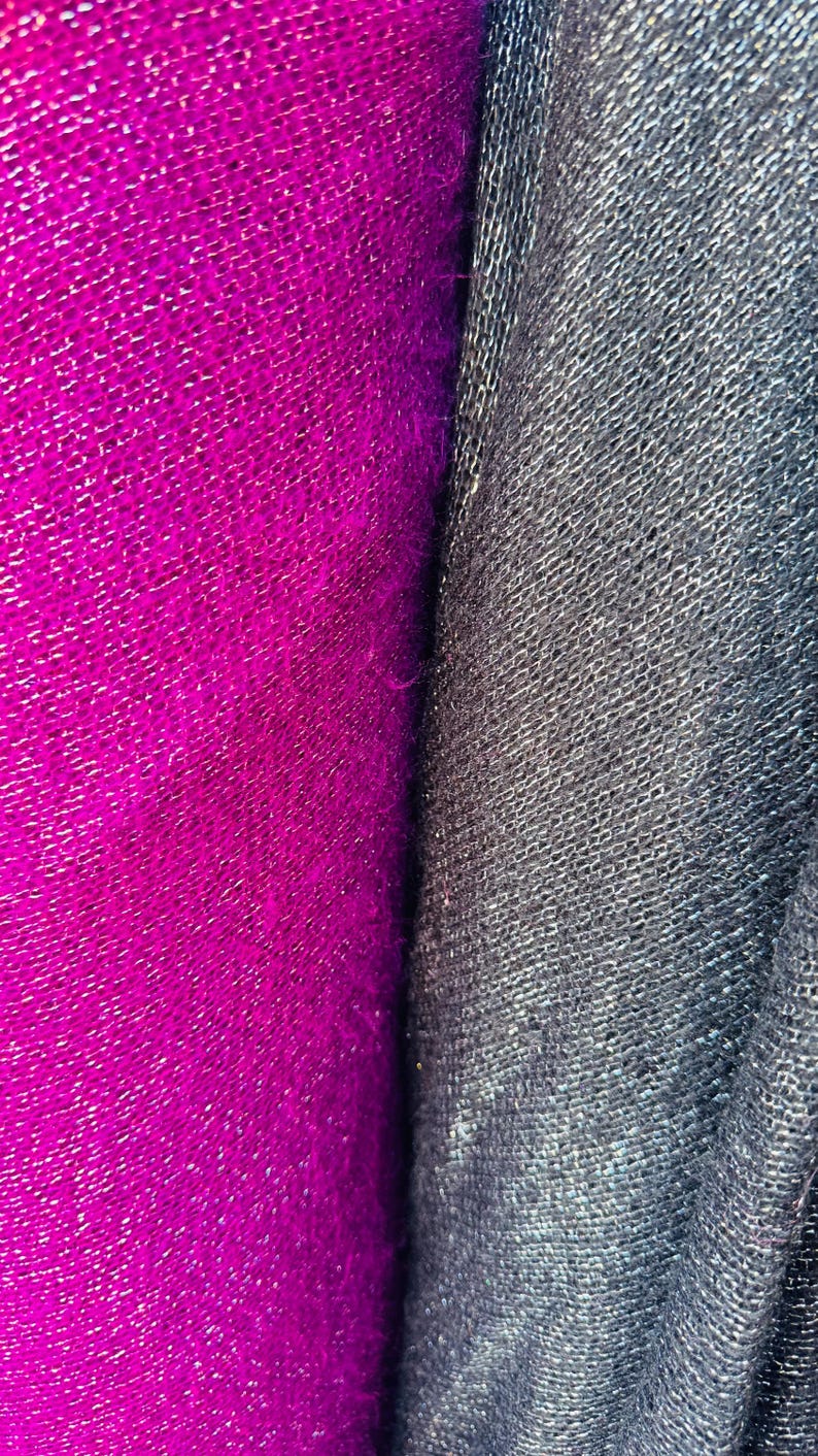 Puede incluir: Primer plano de dos muestras de tela. Una es de color rosa fucsia brillante con una superficie texturizada y tejida. La otra es de color gris oscuro con una superficie texturizada similar.