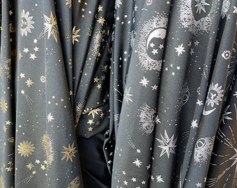 May include: Black fabric with a repeating pattern of silver and gold stars, moons, and suns.