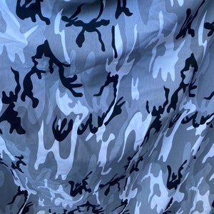 May include: Grey and black camouflage fabric with a wavy pattern.