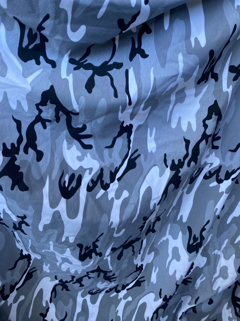 May include: Grey and black camouflage fabric with a wavy pattern.