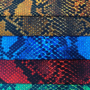 May include: Five different fabric swatches with a snake skin pattern. The swatches are in the colours of brown, blue, red, green, and yellow.