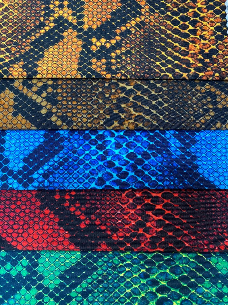 May include: Five different fabric swatches with a snake skin pattern. The swatches are in the colours of brown, blue, red, green, and yellow.
