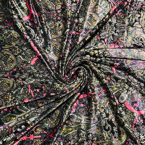 May include: A black velvet fabric with a paisley pattern in shades of pink, green, and gold. The fabric is draped and twisted, creating a swirling effect.
