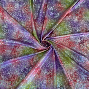 May include: A vibrant fabric with a swirling pattern of colors. The material features a mix of red, pink, green, and purple hues, with a subtle, textured finish. The fabric is folded and draped, creating a dynamic visual effect.