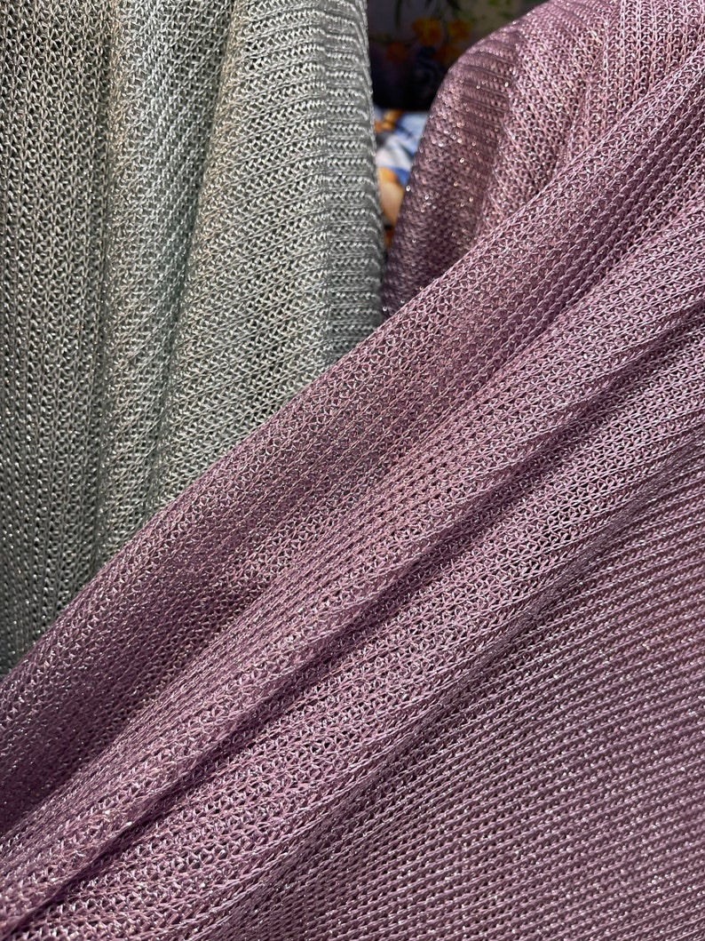 Puede incluir: Dos piezas de tela, una es gris claro y la otra es morado oscuro. Ambas telas tienen un patr&oacute;n tejido texturizado y brillante.