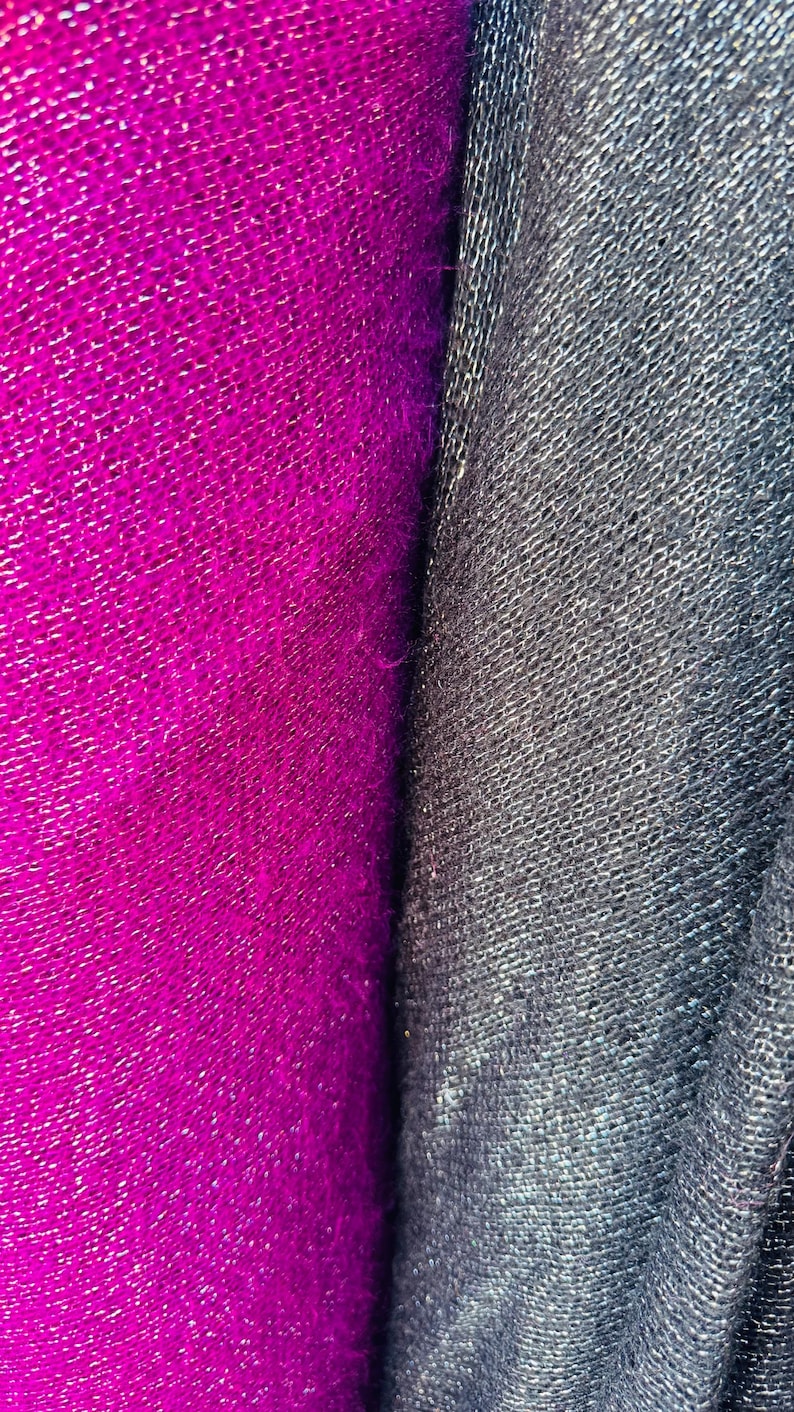 Puede incluir: Primer plano de dos muestras de tela. Una es de color rosa fucsia brillante con una superficie texturizada y tejida. La otra es de color gris oscuro con una superficie texturizada similar.