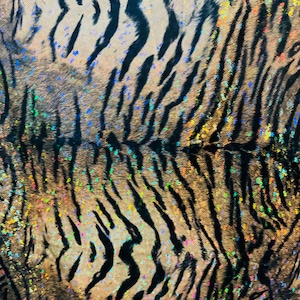 May include: Close-up of a black and brown tiger print fabric with iridescent glitter accents.