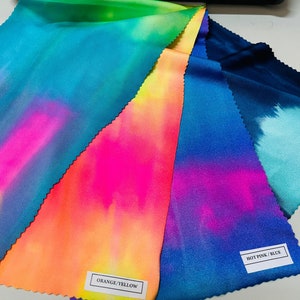 May include: Five fabric swatches with tie-dye patterns in various colors, including blue, green, pink, orange, and yellow. The swatches are labeled with the color combinations: "Multi Pastel", "Orange/Yellow", "Hot Pink/Blue", and "Navy Green".