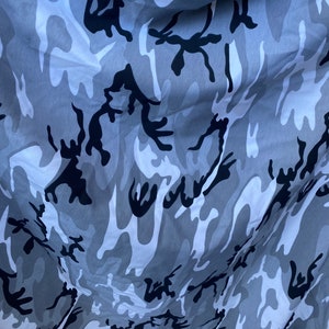 May include: Grey and black camouflage fabric with a wavy pattern.