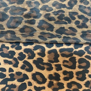 May include: Two pieces of fabric with a leopard print pattern. The top piece is a mesh fabric with a brown and black leopard print. The bottom piece is a solid fabric with a brown and black leopard print.
