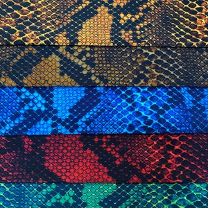 May include: Five different fabric swatches with a snake skin pattern. The swatches are in the colours brown, blue, red, green, and yellow.