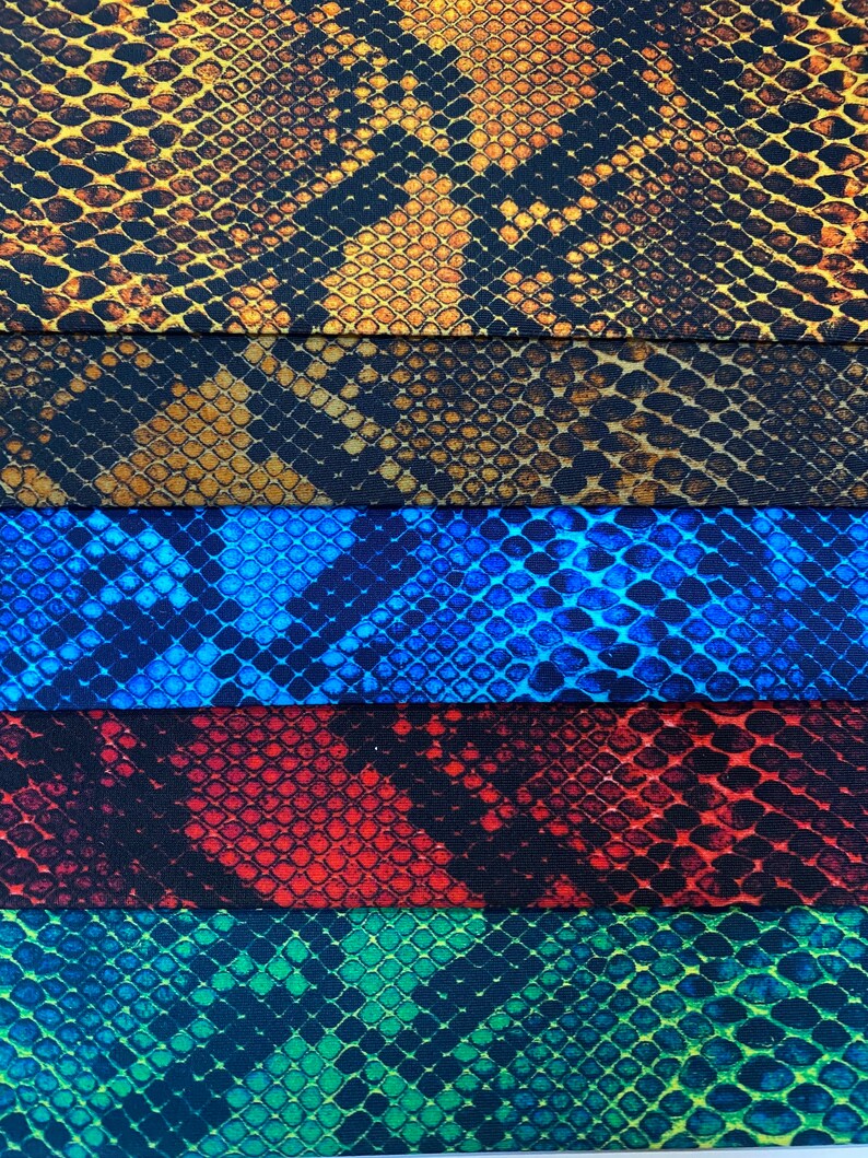 May include: Five different fabric swatches with a snake skin pattern. The swatches are in the colours brown, blue, red, green, and yellow.