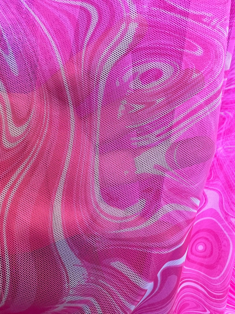 K&ouml;nnte beinhalten: Nahaufnahme eines transparenten rosa Mesh-Stoffs mit einem wirbelnden, marmorierten Muster in Rosa- und Wei&szlig;t&ouml;nen. Der Stoff hat eine feine, wabenartige Textur, die einen halbtransparenten Effekt erzeugt. Das Design erinnert an Fluidit&auml;t und Bewegung.