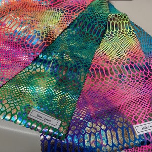 May include: Three swatches of iridescent fabric with a snakeskin pattern. The swatches are labeled "yellow/orange", "lime/green", and "pink/yellow".