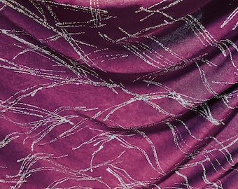 May include: Purple fabric with a silver glitter pattern. The fabric is draped and has a soft, flowing texture.