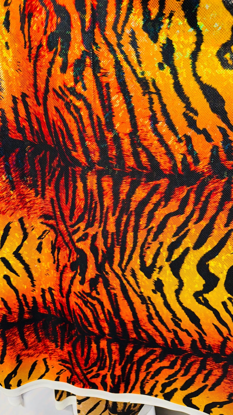 Puede incluir: Primer plano de una tela con un patr&oacute;n de rayas de tigre en naranja, amarillo y negro.