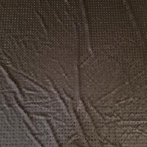 Op de afbeelding: Een donkerbruine stof met een uniform raster van kleine, verhoogde, cirkelvormige stippen over het gehele oppervlak. Het textiel vertoont subtiele vouwen en kreukels, wat zorgt voor een getextureerd uiterlijk met een consistent patroon.