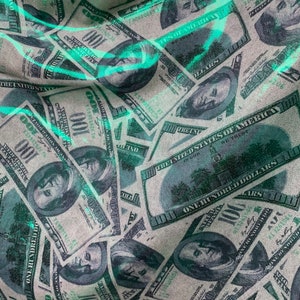 以下が含まれることがあります： アメリカ合衆国100ドル紙幣のパターンが施された布のクローズアップ。紙幣はランダムなパターンで配置され、わずかに重なっています。布は薄い緑色で、わずかにテクスチャのある表面をしています。