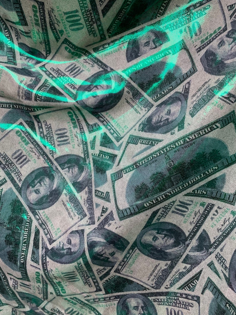 以下が含まれることがあります： アメリカ合衆国100ドル紙幣のパターンが施された布のクローズアップ。紙幣はランダムなパターンで配置され、わずかに重なっています。布は薄い緑色で、わずかにテクスチャのある表面をしています。