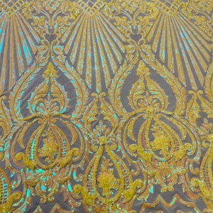 May include: A close-up of iridescent yellow fabric with a damask pattern. The fabric is made of sequins and has a subtle sheen.