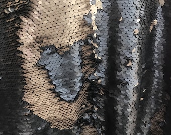 Peut inclure: Gros plan sur un tissu avec des paillettes noires et dorées. Les paillettes sont disposées en un motif qui crée un effet chatoyant.