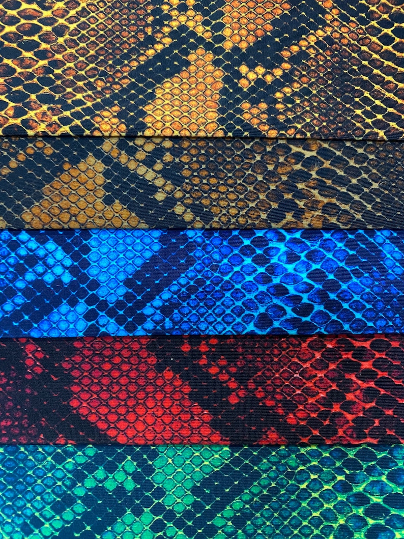 May include: Five fabric swatches with a snake skin pattern. The swatches are in different colours: brown, blue, red, green, and black.