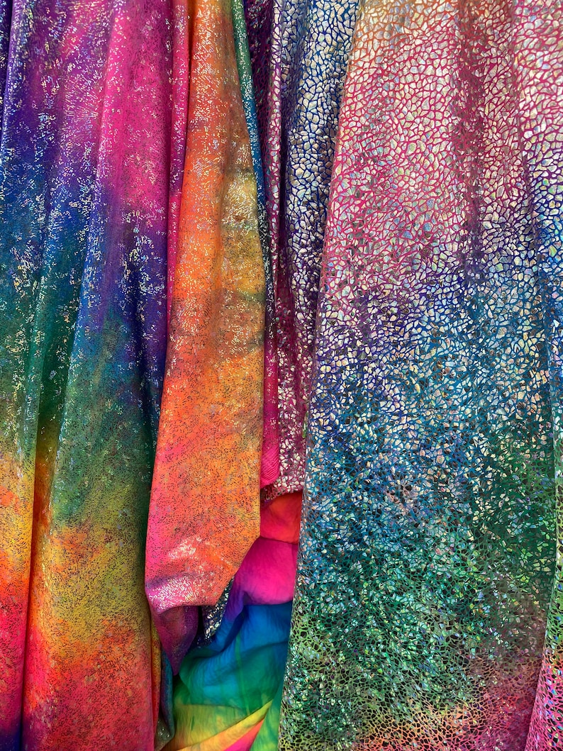 K&ouml;nnte beinhalten: Vier St&uuml;cke regenbogenfarbener, schimmernder Stoff. Der Stoff hat eine strukturierte, glitzernde Oberfl&auml;che.