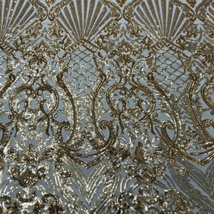 May include: Gold sequin fabric with a white background and a damask pattern.