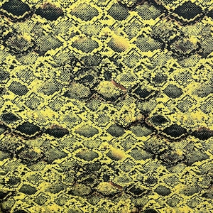 Könnte beinhalten: Gelber und schwarzer Stoff mit Schlangenhautmuster. Der Stoff hat eine strukturierte Oberfläche und ein sich wiederholendes Muster.