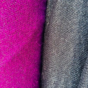 Puede incluir: Primer plano de dos muestras de tela, una de color fucsia vibrante y la otra de color gris antracita oscuro. Ambas telas tienen un aspecto texturizado y tejido.