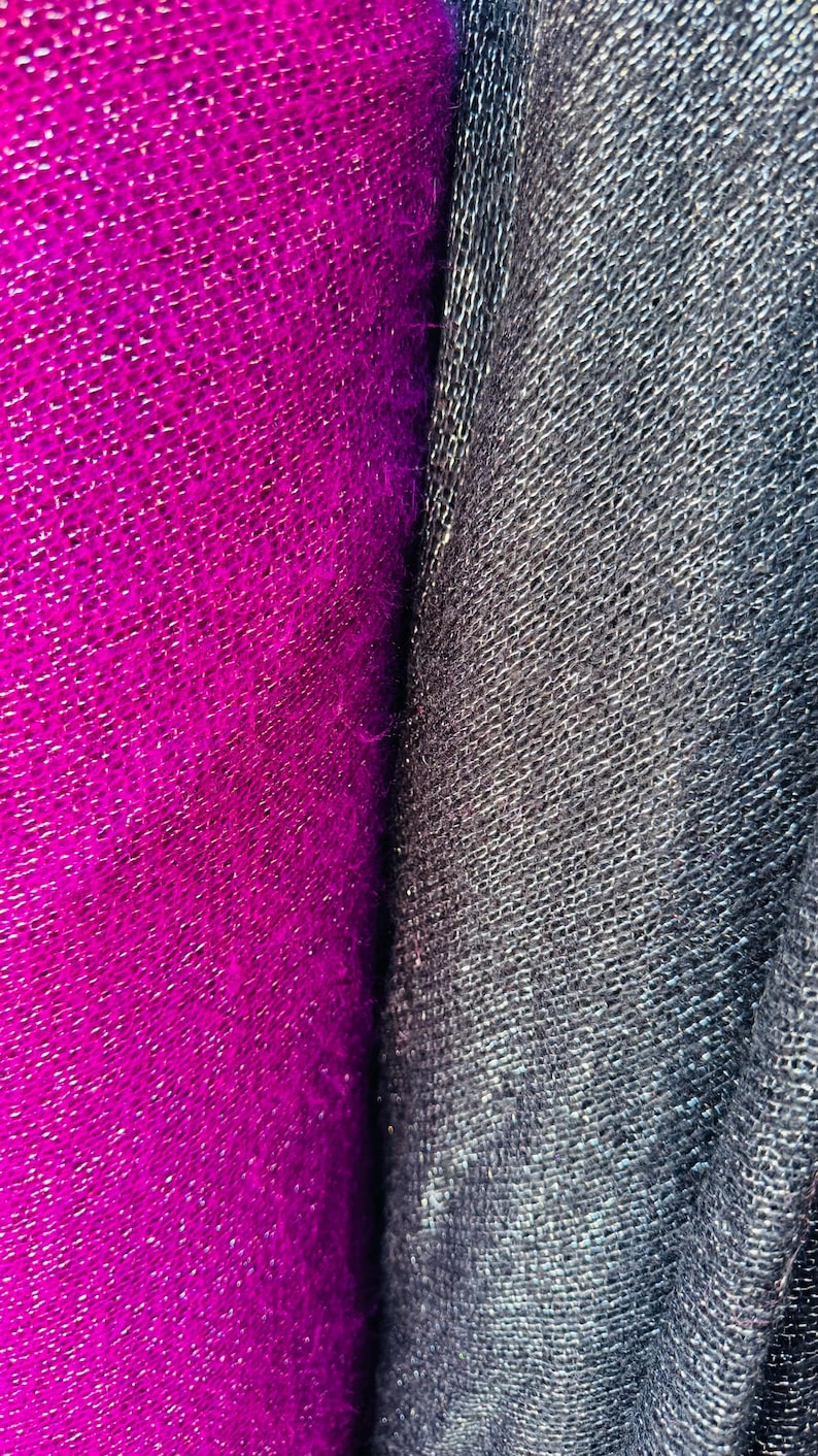 Puede incluir: Primer plano de dos muestras de tela, una de color fucsia vibrante y la otra de color gris antracita oscuro. Ambas telas tienen un aspecto texturizado y tejido.