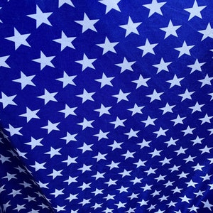 May include: A blue fabric with a repeating pattern of white stars. The stars are arranged in rows and columns, creating a gradient effect.