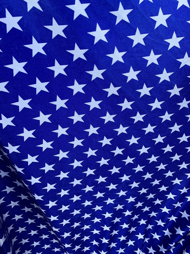 May include: A blue fabric with a repeating pattern of white stars. The stars are arranged in rows and columns, creating a gradient effect.