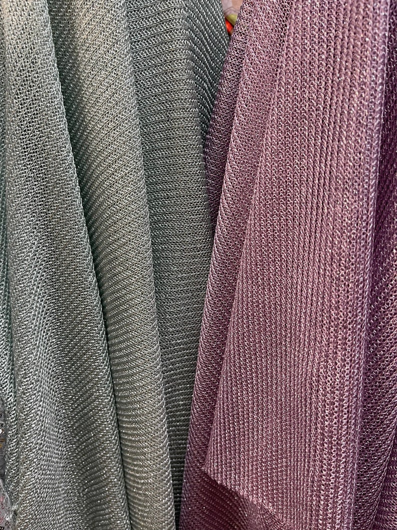 Puede incluir: Dos piezas de tela, una plateada y otra morada, con un patr&oacute;n texturizado y tejido.