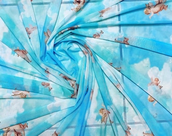 Nuevo diseño de ángeles celestiales divinos, estampado en color azul agua sobre malla de nailon de gran calidad, elástica en 4 direcciones, 58/60”. Se vende por yarda.