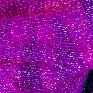 Puede incluir: Primer plano de una tela brillante de color p&uacute;rpura con textura tejida.