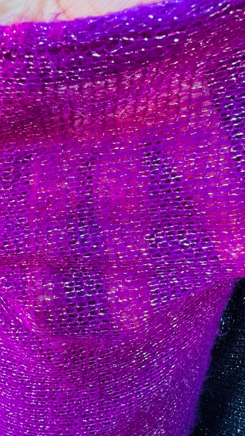 Puede incluir: Primer plano de una tela brillante de color p&uacute;rpura con textura tejida.