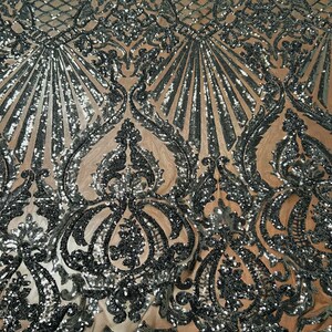 May include: Black and silver sequined fabric with a damask pattern. The fabric is sheer and has a delicate, intricate design.