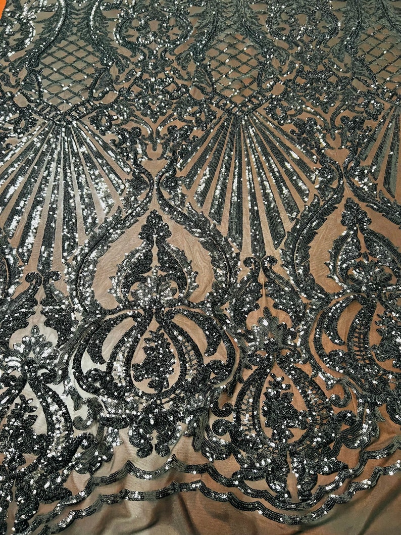 May include: Black and silver sequined fabric with a damask pattern. The fabric is sheer and has a delicate, intricate design.