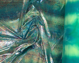 May include: Close-up of iridescent green fabric with a snakeskin pattern. The fabric is folded and draped, showing its texture and shine.