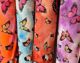 May include: Three rolls of fabric with a butterfly print. The fabric on the left is orange with pink butterflies, the middle fabric is blue with yellow butterflies, and the fabric on the right is purple with pink butterflies.