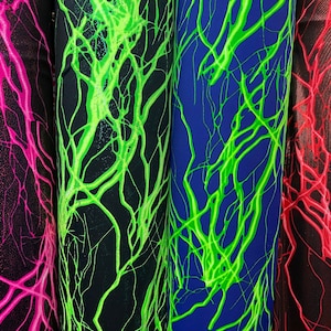 May include: Three fabric swatches with a black background and a bright green lightning bolt pattern. The swatches are pink, blue, and red.