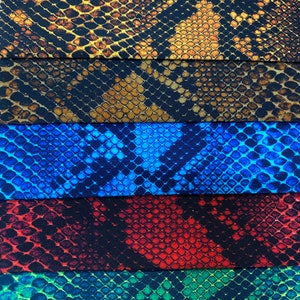 May include: Five different fabric swatches with a snakeskin pattern. The swatches are arranged in a vertical stack. The top swatch is brown and black, the second swatch is brown and black, the third swatch is blue, the fourth swatch is red, and the bottom swatch is green.