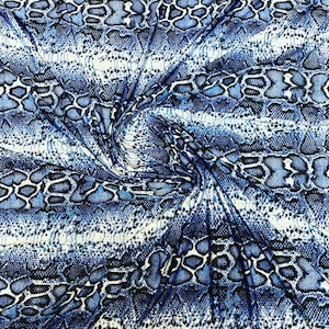 Könnte beinhalten: Blau-weißer Stoff mit Schlangenhautmuster. Der Stoff ist gefaltet und verdreht, wodurch das Muster im Detail sichtbar wird.