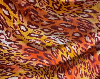 May include: Orange, yellow, and brown leopard print fabric with a subtle shimmer. The fabric has a mesh texture.