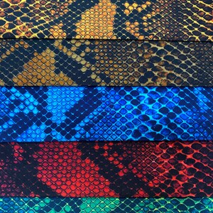 May include: Five different fabric swatches with a snake skin pattern. The swatches are in the colours brown, blue, red, green, and black.